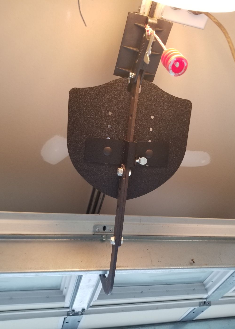 Garage door opener trolley and arm mounted along the overhead track rail