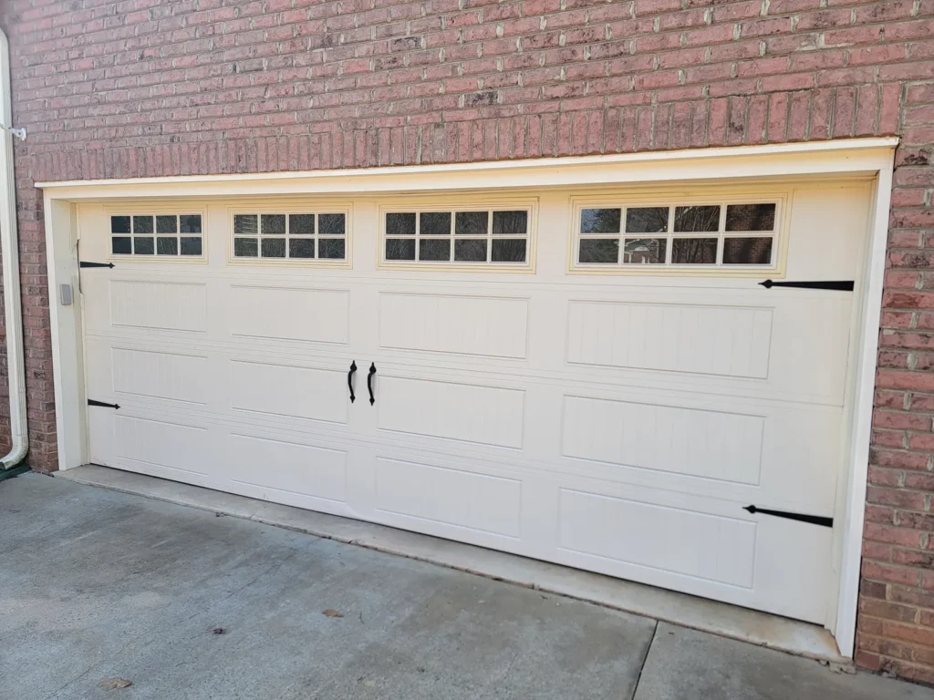 Almond colored carriage style double garage door with windows
