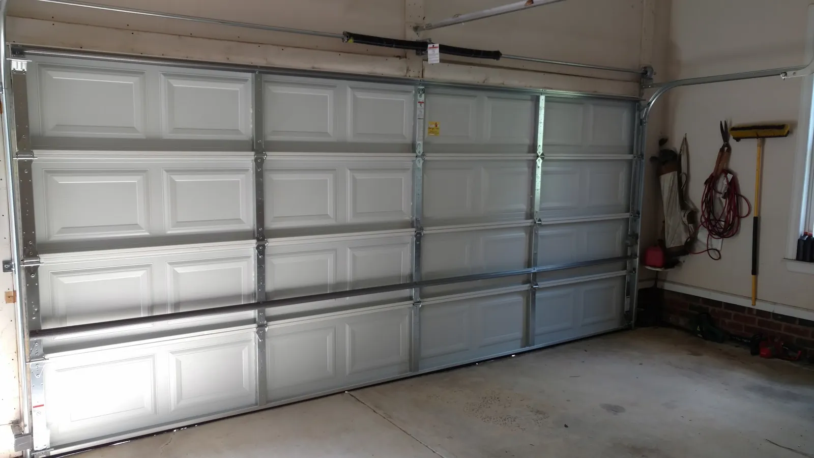 Inside view of a double garage door showing the vertical tracks and rollers