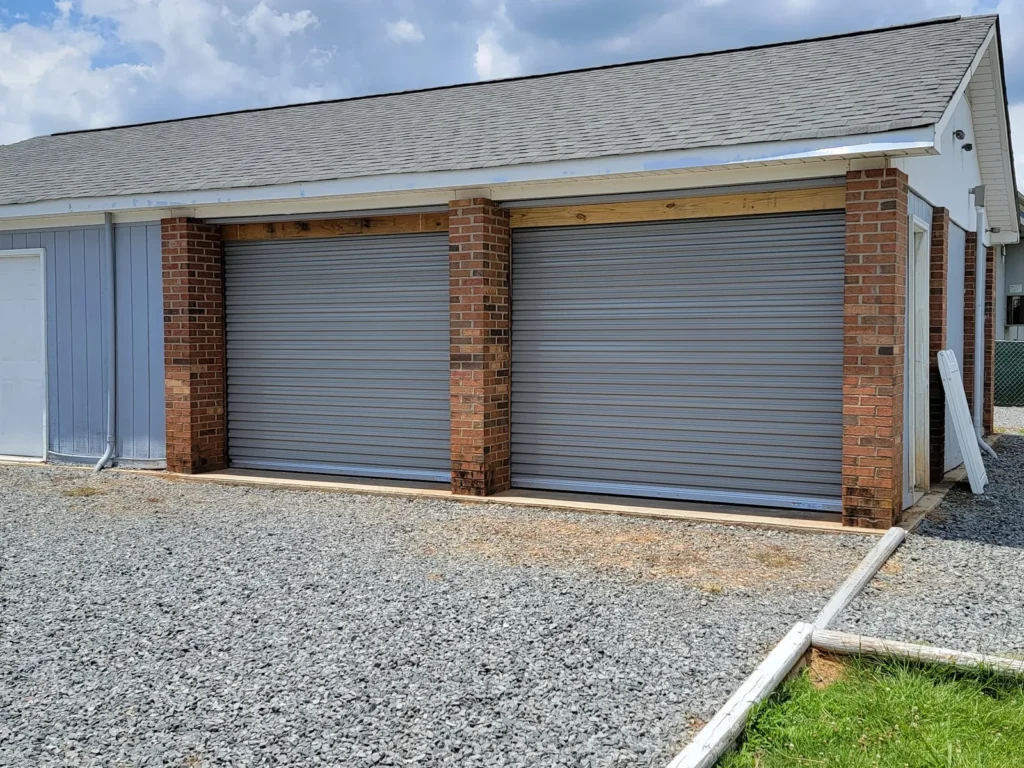 Two gray garage doors between brick columns on a detached garage
