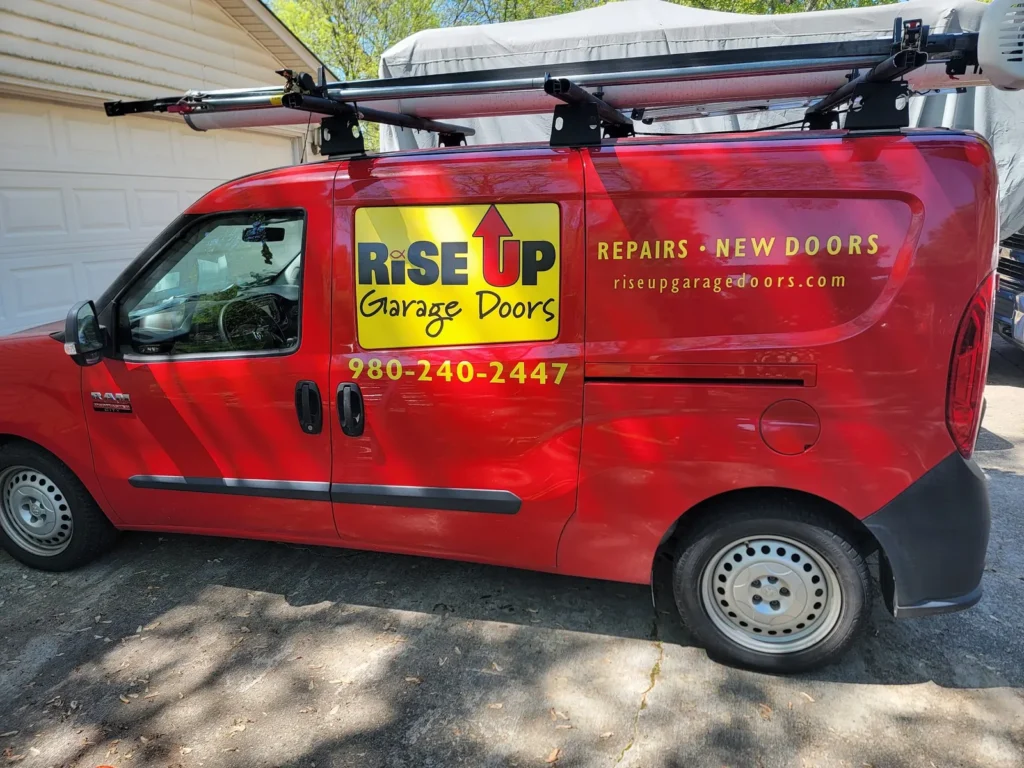 Red Rise Up Garage Doors service van with the company phone number on the side