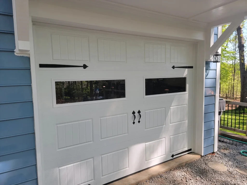 White carriage style garage door with long windows and black strap hinges