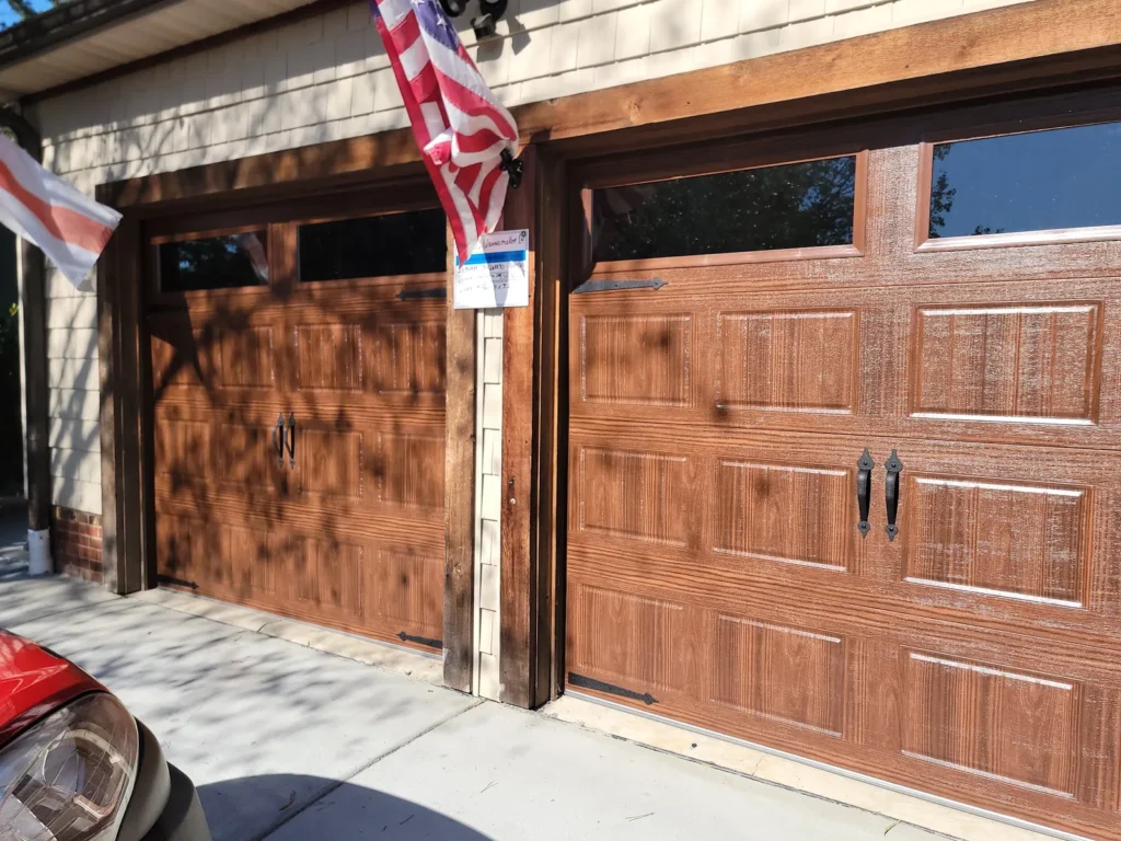 Two woodgrain finish carriage house garage doors with decorative handles