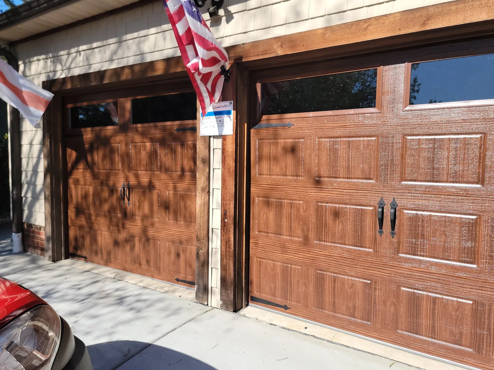 Two woodgrain finish carriage house garage doors with decorative handles